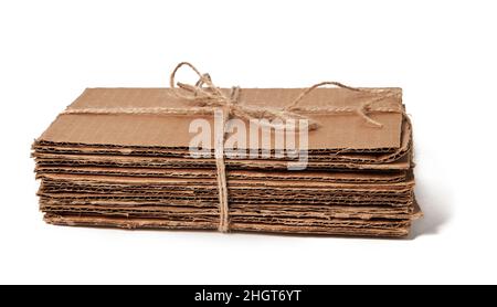 Pile liée de carton ondulé prêt pour le recyclage isolée sur fond blanc.Déchets de papier Banque D'Images