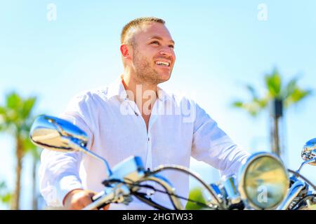 Homme de mode avec scooter dans casque dans les tropiques paradisiaques Banque D'Images