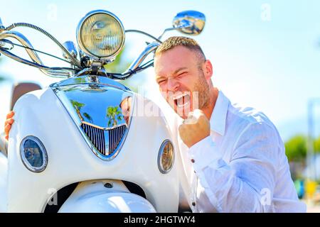 Homme de mode avec scooter dans casque dans les tropiques paradisiaques Banque D'Images