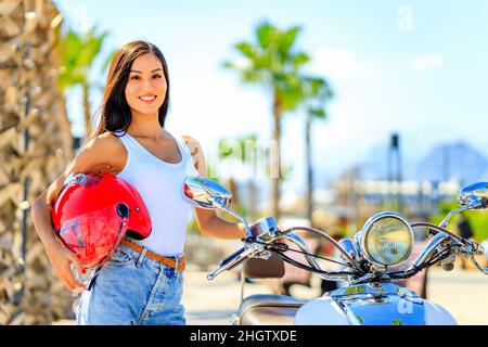 belle femme scooter pilote un vélo profiter de ses week-ends tropicales Banque D'Images