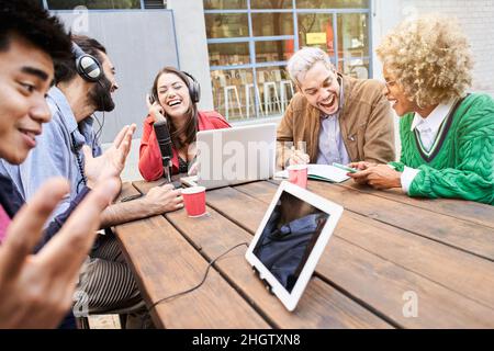 Diffusion audio en extérieur.Balado souriant aux jeunes.Équipe travaillant dans un studio de radio faisant une interview amusante. Banque D'Images