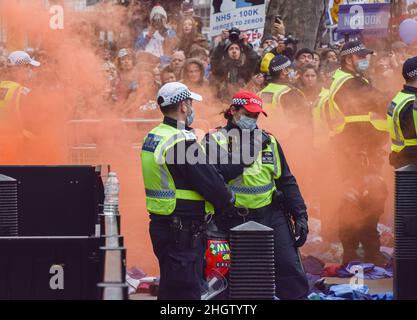 Londres, Royaume-Uni.22nd janvier 2022.Les policiers sont vus entourés de fumée par une éruption d'un démonstrateur et les uniformes du personnel hospitalier sont vus au sol,Des milliers de personnes ont défilé dans le centre de Londres pour protester contre les vaccins obligatoires pour le personnel du NHS (National Health Service), les masques faciaux, les vaccins Covid-19, les passeports de vaccination et d'autres griefs alimentés par des théories conspirationnistes.(Photo de Vuk Valcic/SOPA Images/Sipa USA) crédit: SIPA USA/Alay Live News Banque D'Images