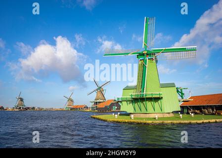 Moulins à vent traditionnels le long du bord de l'eau à Zaanse Schans, pays-Bas sous un ciel typiquement hollandais Banque D'Images
