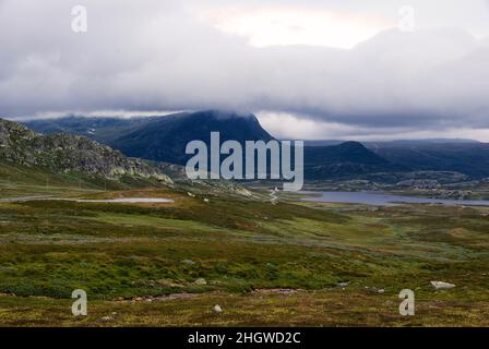 Paysage montagneux avec un lac un matin gris et nuageux à Jotunheimen Nasjonalpark à Innlandet fylke en Norvège. Banque D'Images