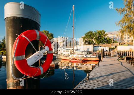 Riga, Lettonie.Bouée de sauvetage suspendue sur Un poteau près de City Pier Harbour Bay et Quay en été Sunny Evening. Banque D'Images