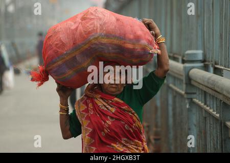 Kolkata, Bengale occidental, Inde.21st janvier 2022.Une femme âgée s'occupe des produits végétaux en traversant le pont Howrah un matin d'hiver à Kolkata le 21 janvier 2022.(Credit image: © Dipa Chakraborty/Pacific Press via ZUMA Press Wire) Banque D'Images