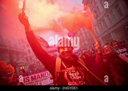 Londres, Royaume-Uni.22nd janvier 2022.Les manifestants tiennent des fusées brulantes tout en marchant dans le centre de Londres pendant la manifestation.Des manifestants ont défilé dans le centre de Londres lors d'un rassemblement mondial pour la liberté, protestant contre les restrictions gouvernementales entourant Covid 19, y compris la vaccination obligatoire, en particulier avec le personnel du NHS, qui risque de perdre son emploi s'ils refusent de se faire vacciner.Crédit : SOPA Images Limited/Alamy Live News Banque D'Images