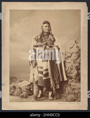 Hinmatóowyalahtq’it (le chef Joseph) 1879 Charles Milton Bell American en 1879, alors que la force se limitait à une réserve dans l’actuel Oklahoma, Hinmatóowyalahtq’it,Ou le chef Joseph, a été autorisé à se rendre à Washington, D.C., où il a rencontré le président Rutherford B. Hayes et a présenté son argument pour le retour de la Perce de nez dans le Nord-Ouest du Pacifique.Comme il était courant pour les délégués autochtones qui visitaient la capitale, il a posé pour un portrait photographique dans le studio de Bell.Debout dans un paysage artificiel composé d'un rocher paper-mâché, de fausse mousse et d'un fond peint, le chef Joseph regarde dans le Banque D'Images