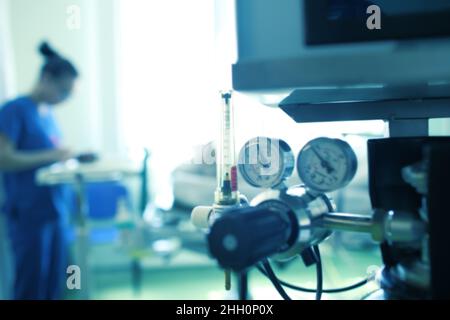 Silhouette floue d'une travailleuse médicale sur fond d'équipement à gaz, arrière-plan non focalisé. Banque D'Images