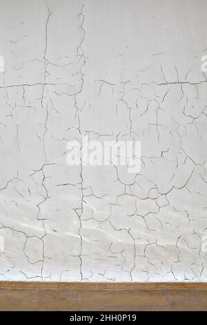 Motif de fissures sur le mur enduit de plâtre blanc, fond texturé. Banque D'Images