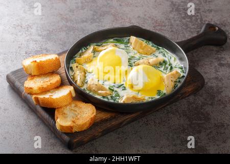 Œufs de style Nouvelle-Orléans Sardou œufs pochés à l'Artichaut, à l'épinards et à la hollandaise dans l'assiette de la table.Horizontale Banque D'Images