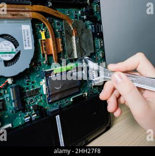 Le technicien de maintenance installe de nouvelles puces sur l'ordinateur portable.Réparation et mise à niveau du concept d'ordinateur portable.Gros plan. Banque D'Images