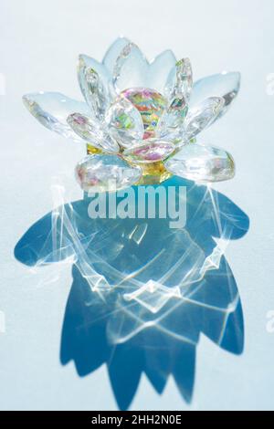 Belle fleur de lotus en cristal sur une table bleue ensoleillée. Banque D'Images