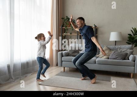 Rire joyeux petit enfant dansant avec un père joyeux. Banque D'Images