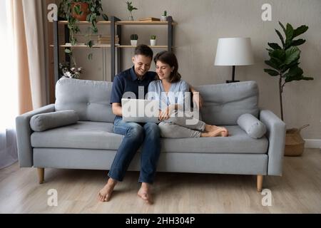 Joyeux couple de jeunes familles en utilisant un ordinateur portable. Banque D'Images