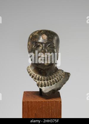 Homme à tête chauve portant des colliers dorés ca.1295–1186 C.-B. Nouveau Royaume cette tête venait d’une petite statue d’un homme à tête blanche qui était probablement placé dans un sanctuaire funéraire pour recevoir des offrandes ou un temple en grace que l’individu résidait en présence d’un dieu.Le pilier arrière affiche le début d'une formule classique d'offre utilisée sur les statues pour ces deux endroits, mais une petite statue d'un type similaire a été trouvée dans un dépôt associé à un grand temple.Le double collier de perles en anneau, connu sous le nom de shebyu, indique que la statue représentait un officiel privilégié.Les dommages délibérés à t Banque D'Images