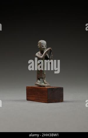 Statuette d'un flûtiste ca.4th siècle av. J.-C. ou plus tard période tardive–période Ptolemaic cette petite statuette en bronze représente un homme debout sur une base avec sa jambe gauche vers l'avant.Il porte une casquette de crâne et un long vêtement droit enveloppé à l'avant.L'artiste n'a pas différencié les mains des instruments qu'il tient, mais ses mains levées tiennent clairement deux flûtes.Sa main droite est levée plus haut que l'autre, plaçant les flûtes à sa gauche, où il pourrait respirer l'air dans eux pour les jouer.Comme l'homme joue éternellement ses instruments, sa figure fait allusion à l'importance de la musique et m Banque D'Images
