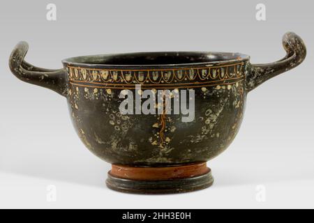 Skyphos en terre cuite deuxième moitié du 4th siècle C.-B. grec, sud-italien, Gnathian les motifs polychromes et les motifs sur ce skyphos créés en appliquant le jaune et le blanc directement sur le noir brillant avant que le navire ait été tiré, sont caractéristiques du 'style Gnathian'.Le terme est dérivé de l'ancien nom du site de Gnathia où un grand nombre d'exemples de ce type ont été découverts.Lignes fines dans les modèles jaune évoquent avec décoration dorée.Skyphos en terre cuite.Grec, Sud-italien, Gnathian. Deuxième moitié du siècle 4th av. J.-C.Terre cuite.Classique.Vases Banque D'Images