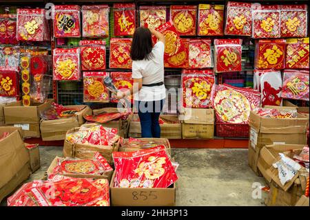 Kuala Lumpur, Malaisie.23rd janvier 2022.Une femme choisit des décorations pour le nouvel an chinois dans un magasin à Kuala Lumpur, Malaisie, le 23 janvier 2022.Les gens décorent leurs maisons avec des plantes et des fleurs, ainsi que des décorations traditionnelles telles que des lanternes rouges et des couplets comme le nouvel an chinois attire plus près.Credit: Zhu Wei/Xinhua/Alay Live News Banque D'Images