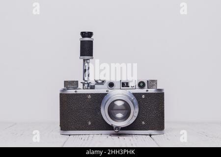 Un ancien appareil photo rétro avec retardateur est situé sur une table en bois.L'arrière-plan est blanc Banque D'Images