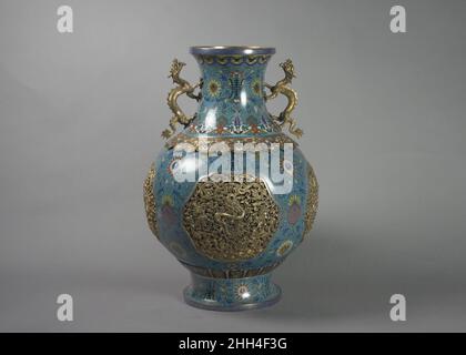 Une des deux vases avec poignées de dragon Chine du 19th siècle les dragons dans les quatre cartouts ajourés sur ce vase sont étonnamment semblables à ceux trouvés sur les robes dans cette galerie et illustrent le partage omniprésent des motifs qui caractérise l'art chinois dans la dynastie Qing.Ce vase faisait probablement partie d'un ensemble qui comprenait un autre vase, un brûleur à encens et des chandeliers, qui seraient exposés dans les salles publiques et sur les autels ancestraux.Ce vase est conçu pour être tourné sur sa base, un ornement technique qui se trouve également (rarement) dans la porcelaine mais n'a pas de fonction réelle.Un Banque D'Images