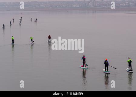 Southend on Sea, Essex, Royaume-Uni.23rd janvier 2022.Le matin s'est enfui sur l'estuaire de la Tamise et s'est embué avec l'eau encore très peu de vent.Un groupe de paddleboarding a été sorti tôt dans l'estuaire et on voit revenir vers Chalkwell après avoir passé Southend Pier à marée basse Banque D'Images