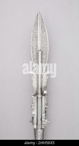 Lance-sanglier avec pistolet à double barrel Wheellock fin du 16th siècle allemand la lame est lancéolate dans sa partie avant, entièrement recouverte de décoration gravée de la strapwork entrelacé, et avec deux crochets courbes de mariage en forme de dauphins dans sa section arrière.La lame est placée entre deux barils de pistolet, sa crête médiane est éliminée et transformée en un canal peu profond de chaque côté aligné avec l'alésage des barils.Entre la lame et la douille cylindrique lourde sont fixés les deux verrous de roue avec roues couvertes.Les déclencheurs de pliage sont à mi-hauteur de l'arbre, insérés en long Banque D'Images