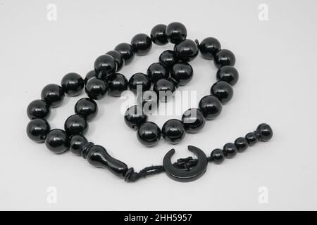 Perles de prière noires pour le culte et dhikr des musulmans sur fond blanc. Banque D'Images