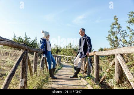 Homme et femme se regardant l'un l'autre penchée sur un pont en bois Banque D'Images