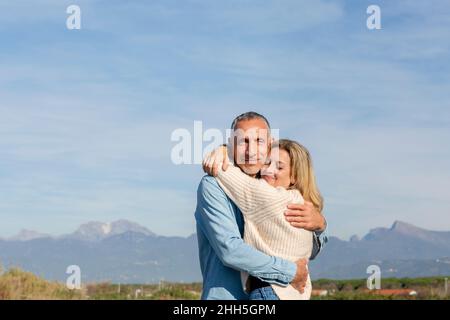 Couple s'embrassant les uns les autres par beau temps Banque D'Images
