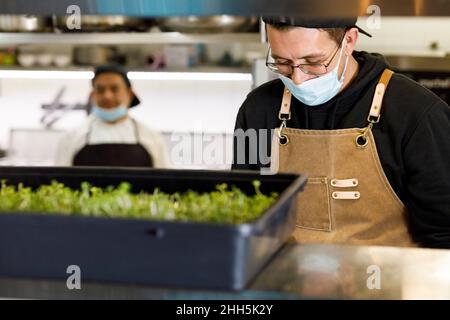 Chef avec masque de protection au restaurant Banque D'Images