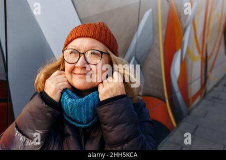 Femme âgée contemplative tenant un foulard sur le sentier Banque D'Images