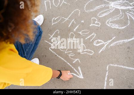 Femme qui dessine avec de la craie dans la rue Banque D'Images