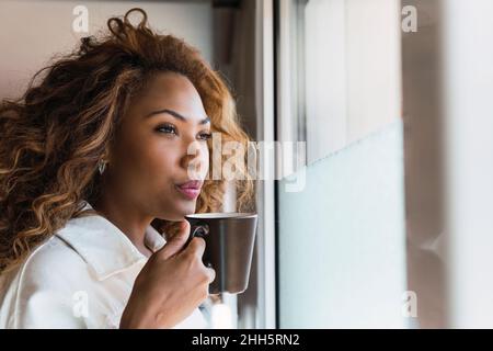 Young woman having coffee at home Banque D'Images