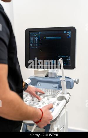 Médecin utilisant le clavier sur l'équipement médical dans l'hôpital Banque D'Images