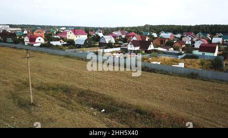 Vue aérienne du village de chalets près du champ vide pour la construction future à la fin de l'été contre ciel bleu nuageux.Magnifique paysage de campagne Banque D'Images