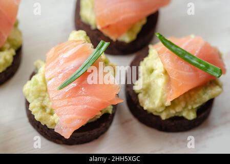 Pâte d'avocat au saumon sur du pain de pumpernickel de grain entier Banque D'Images