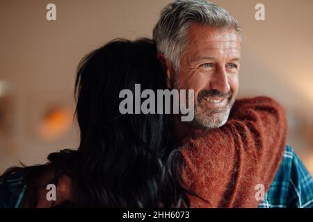 Femme embrassant homme souriant à la maison Banque D'Images