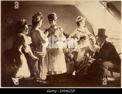 [Un groupe de six femmes costumés posé à l'intérieur avec des messieurs toqués] ca.1885 Inconnu.[Un groupe de six femmes costumés posé à l'intérieur avec des hommes toqués].Inconnu (français).1885. Impression argentée à partir d'un négatif en verre.Photographies Banque D'Images