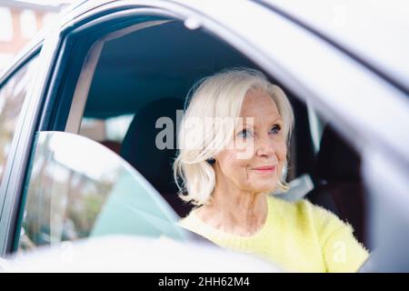 Femme âgée souriante avec voiture à cheveux blancs Banque D'Images