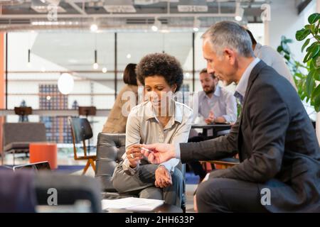 Homme d'affaires donnant un stylo à un collègue pour avoir signé un contrat au bureau Banque D'Images