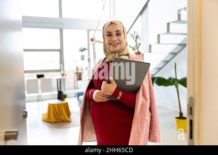 Bonne femme enceinte avec dossier à la maison Banque D'Images