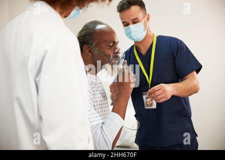 Masque d'oxygène réglable par le patient avec des experts en soins de santé dans la salle médicale Banque D'Images