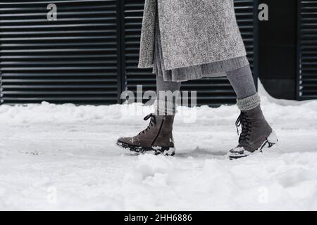 Femme portant des bottes de neige marchant sur le sentier Banque D'Images