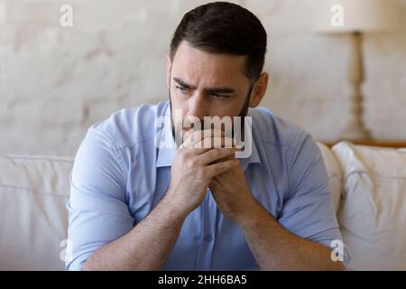 Inquiet inquiet homme d'affaires du millénaire pensant à de mauvaises nouvelles Banque D'Images