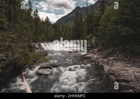 L'eau coule sur McDonald Creek en direction de Sun Road dans le parc national Glacier Banque D'Images