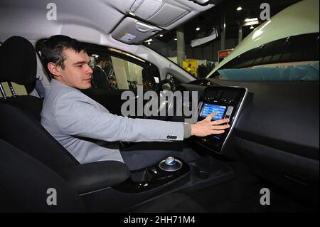 Conducteur masculin manipulant un écran tactile dans la cabine d'une nouvelle voiture électrique.PLUG-IN D'EXPOSITION UKRAINE 2018.2 mars 2018.Centre d'exposition de Kiev.Kiev Banque D'Images