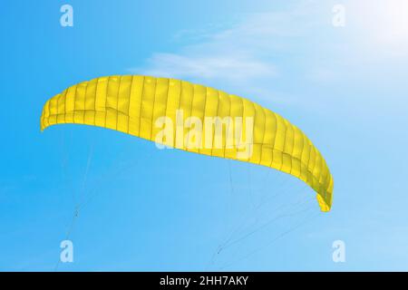 Parachute jaune voler dans un ciel bleu Banque D'Images