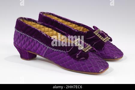 Chaussons 1865–85 D.E.Burt & Co. Fine Shoes les vêtements spéciaux pour les occasions sont les plus souvent conservés, donc tandis que les chaussures de mariage et de soirée sont généralement bien représentées dans les collections historiques, les vêtements de détente survivants, comme cette paire de chaussons de boudoir, sont moins courants.Cet exemple attrayant et joliment détaillé met en évidence le goût dominant pour un arrangement de couleurs profond et riche.La couleur violet vif a été rendue possible par la découverte et le développement de colorants synthétiques à partir de la fin de 1850s.Pantoufles.Américain.1865–85. soie, métal Banque D'Images