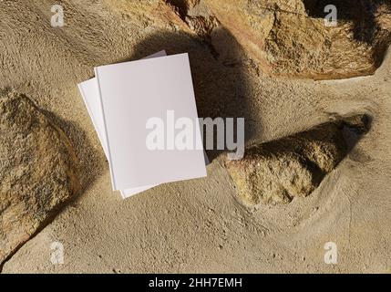 Modèle de livre vierge placé sur des rochers dans le sable, maquette de bloc-notes, maquette sur fond de nature 03 Banque D'Images